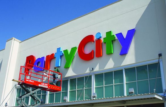 A worker finishes installing the Party City sign Sept. 14 in Fairplain Plaza. Party City is slated to open its new location Friday. (Tony Wittkowski | HP Staff)